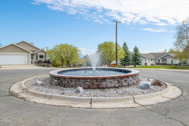 view of property's community with an attached garage and curved driveway