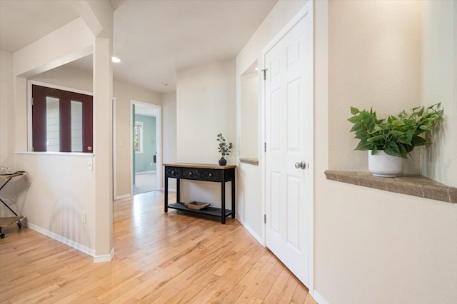 hallway featuring light wood-type flooring, baseboards, and recessed lighting