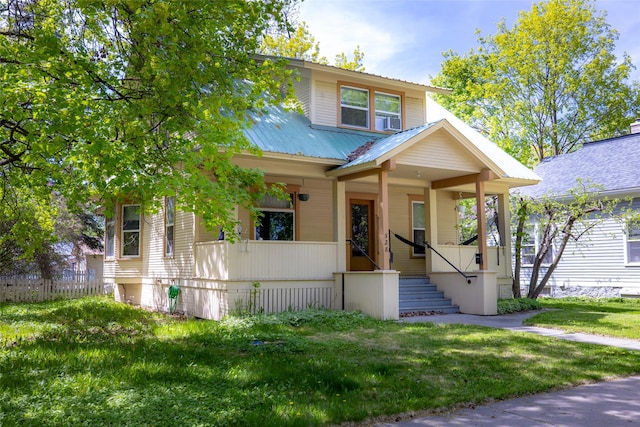 528 3rd Ave E, Kalispell, MT 59901 - view of front of house featuring covered porch, a front yard, metal roof, and stairway