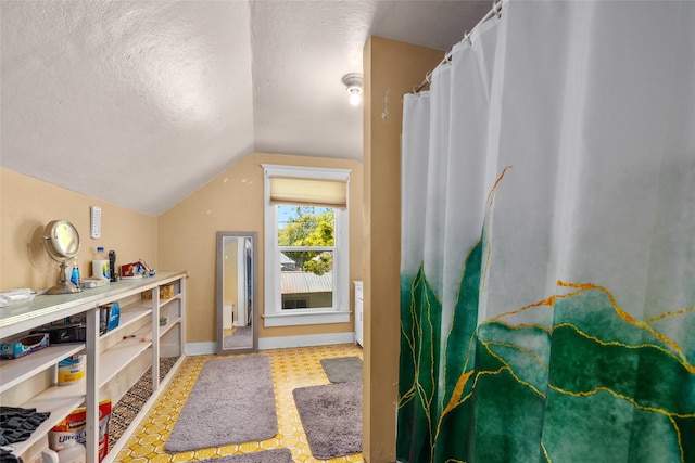 528 3rd Ave E, Kalispell, MT 59901 - bonus room featuring vaulted ceiling, a textured ceiling, baseboards, and tile patterned floors