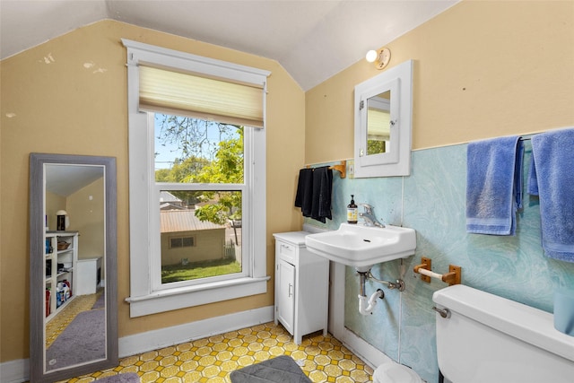 528 3rd Ave E, Kalispell, MT 59901 - half bathroom with vaulted ceiling, toilet, baseboards, and a sink