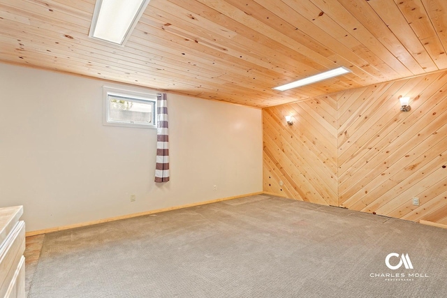 additional living space featuring carpet floors, wood ceiling, wooden walls, and baseboards