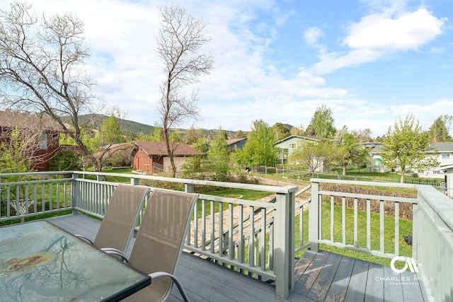 wooden deck featuring a residential view and a lawn