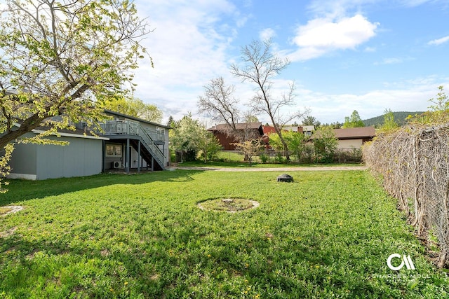 view of yard with stairs and a deck