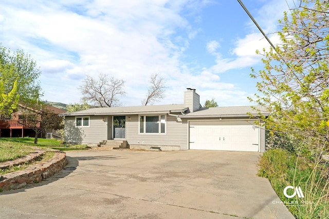 view of front of property with driveway, a garage, and a chimney