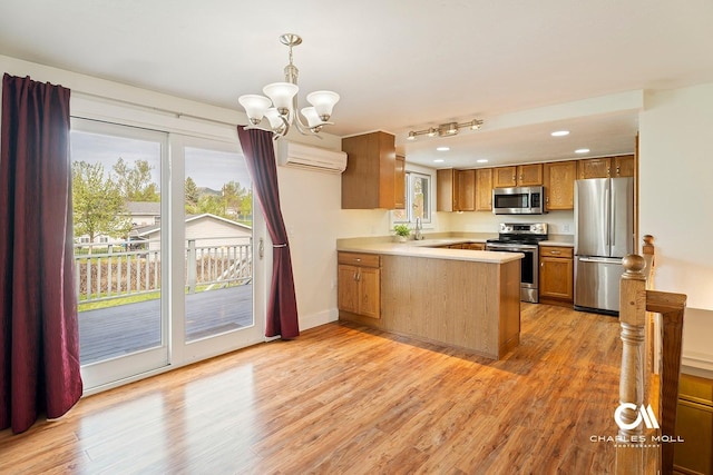 kitchen with stainless steel appliances, a wall mounted air conditioner, a peninsula, brown cabinets, and light countertops