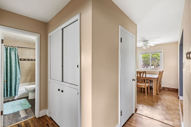 corridor with wood finished floors and baseboards