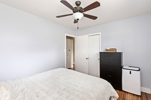 bedroom featuring wood finished floors, baseboards, a closet, and ceiling fan
