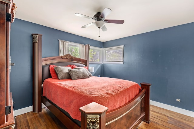 bedroom with wood finished floors, baseboards, and a ceiling fan