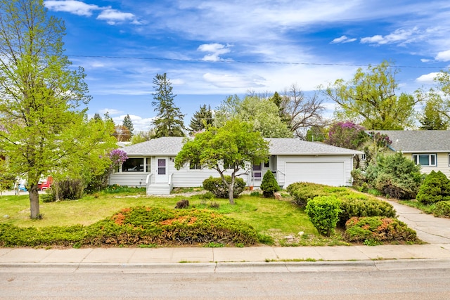 view of front of property featuring entry steps, an attached garage, and a front lawn