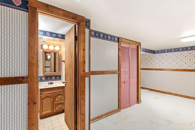 bathroom featuring wallpapered walls and vanity