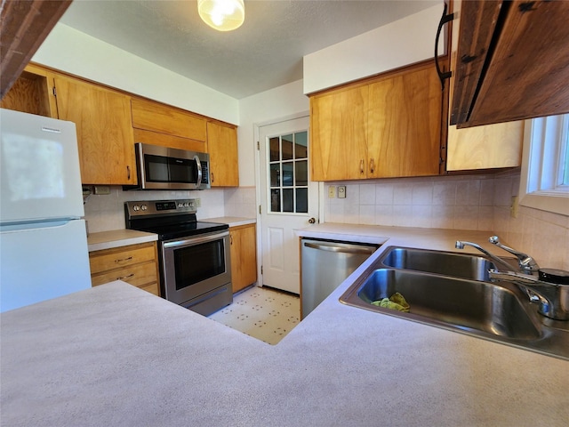 172 Scenery Rd, Libby, MT 59923 - kitchen featuring stainless steel appliances, a sink, tasteful backsplash, light countertops, and brown cabinetry