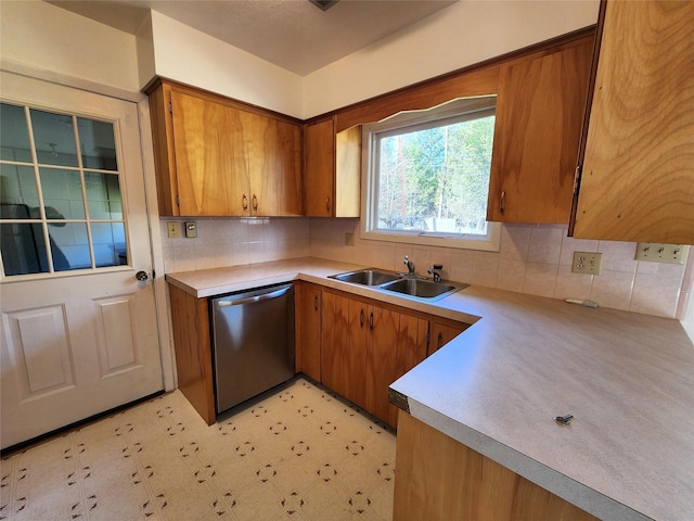 172 Scenery Rd, Libby, MT 59923 - kitchen featuring dishwasher, a sink, brown cabinetry, light countertops, and backsplash