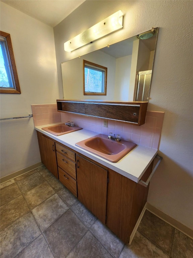 172 Scenery Rd, Libby, MT 59923 - bathroom with double vanity, baseboards, tasteful backsplash, and a shower with shower door