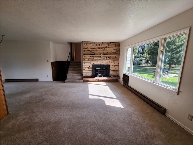 172 Scenery Rd, Libby, MT 59923 - unfurnished living room featuring baseboard heating, carpet flooring, a textured ceiling, stairway, and a baseboard heating unit