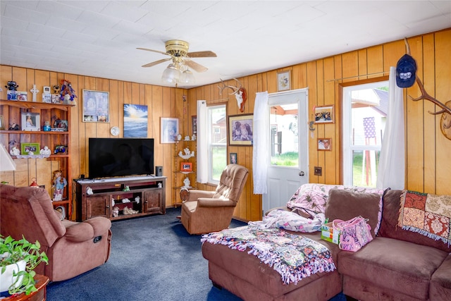 1005 Idaho Ave, Libby, MT 59923 - living room featuring plenty of natural light, carpet floors, a ceiling fan, and wooden walls