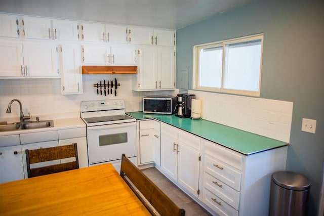 kitchen featuring white range with electric stovetop, a sink, stainless steel microwave, backsplash, and white cabinetry