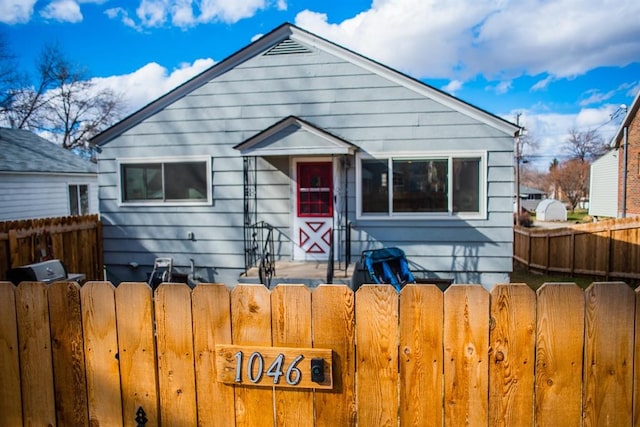 bungalow-style home with fence