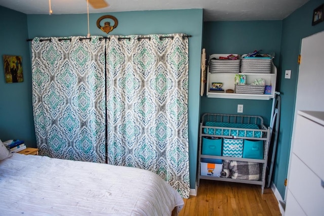 bedroom with wood finished floors and baseboards