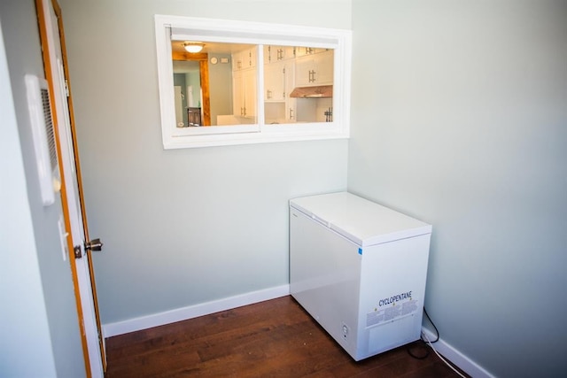 interior space featuring fridge, wood finished floors, and baseboards