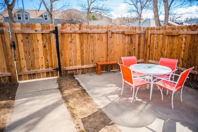 view of patio / terrace featuring a gate, fence, and outdoor dining area
