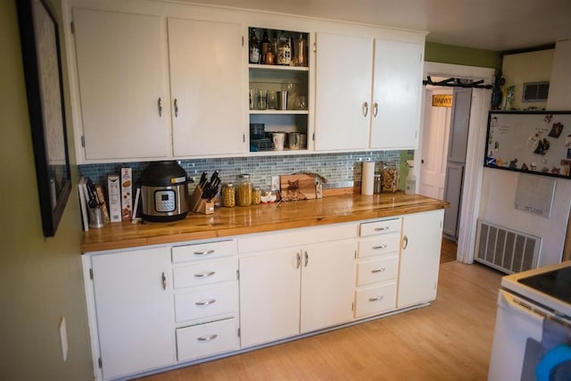 kitchen featuring tasteful backsplash, light wood finished floors, white cabinetry, open shelves, and wooden counters