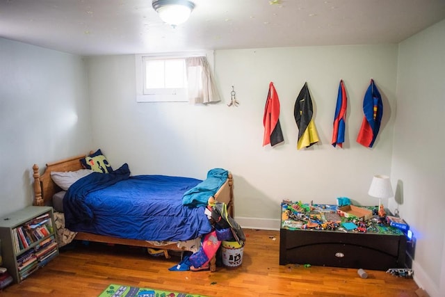 bedroom with wood finished floors and baseboards