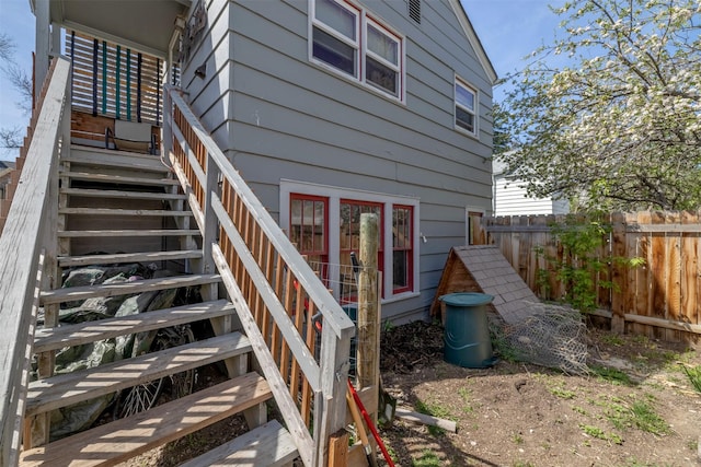 back of house featuring fence and stairs