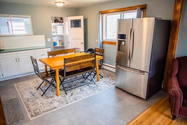 dining area with plenty of natural light and baseboard heating