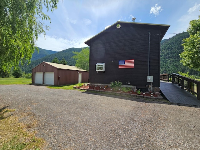 4743 Sloway Frontage Rd, Superior, MT 59872 - view of side of property featuring a garage, an outdoor structure, and a deck with mountain view