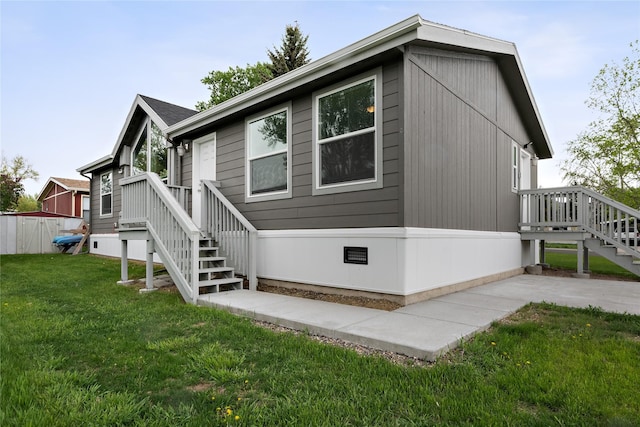 rear view of house with stairs, a yard, and crawl space