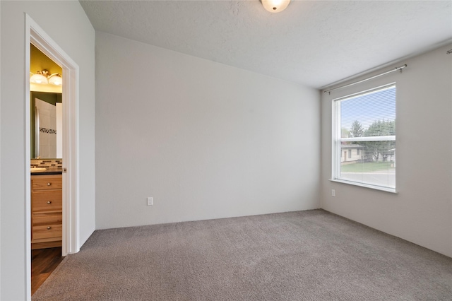 unfurnished bedroom with carpet flooring and ensuite bathroom