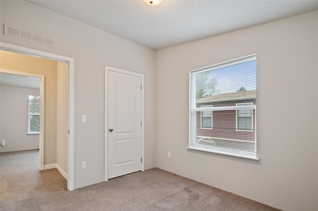 carpeted empty room with healthy amount of natural light