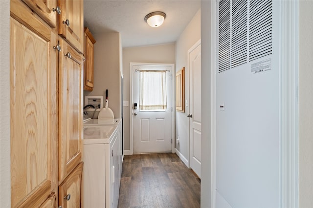 laundry room with a heating unit, separate washer and dryer, cabinet space, dark wood-type flooring, and baseboards