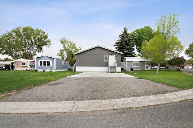manufactured / mobile home with a front lawn and asphalt driveway