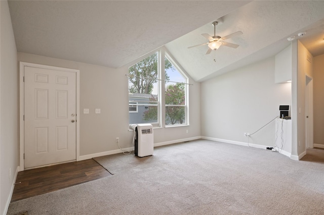 unfurnished living room featuring carpet, a ceiling fan, lofted ceiling, and baseboards
