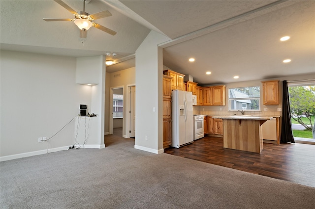kitchen featuring dark colored carpet, white appliances, a kitchen breakfast bar, vaulted ceiling, and light countertops