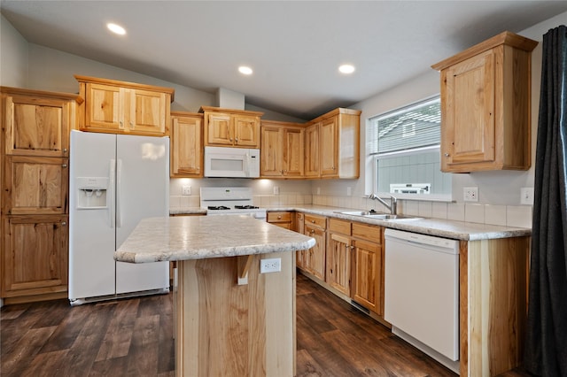 kitchen featuring white appliances, a sink, lofted ceiling, light countertops, and a kitchen island