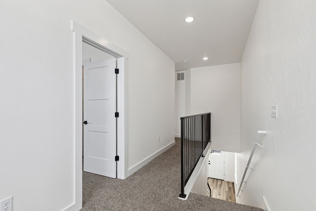 corridor with an upstairs landing, recessed lighting, light colored carpet, and baseboards