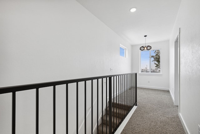 corridor featuring carpet floors, baseboards, a chandelier, and recessed lighting
