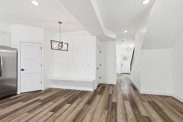 unfurnished dining area with a chandelier, wood finished floors, recessed lighting, and baseboards