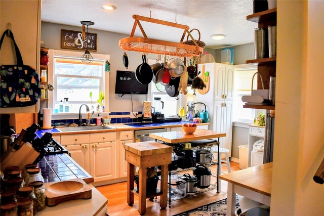1314 Dakota Ave, Libby, MT 59923 - kitchen featuring tile counters, a sink, light wood finished floors, hanging light fixtures, and open shelves
