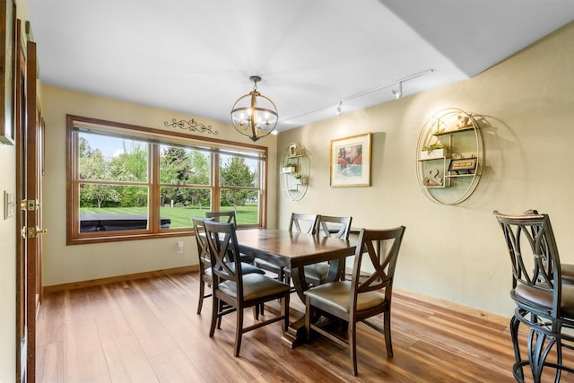 1815 Homestead Dr, Missoula, MT 59808 - dining room with rail lighting, a chandelier, wood finished floors, and baseboards