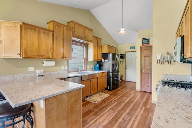 1815 Homestead Dr, Missoula, MT 59808 - kitchen featuring stainless steel appliances, a sink, a peninsula, lofted ceiling, and light wood finished floors