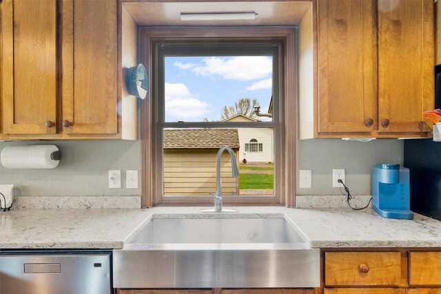 1815 Homestead Dr, Missoula, MT 59808 - kitchen featuring a sink, stainless steel dishwasher, brown cabinets, and light stone countertops