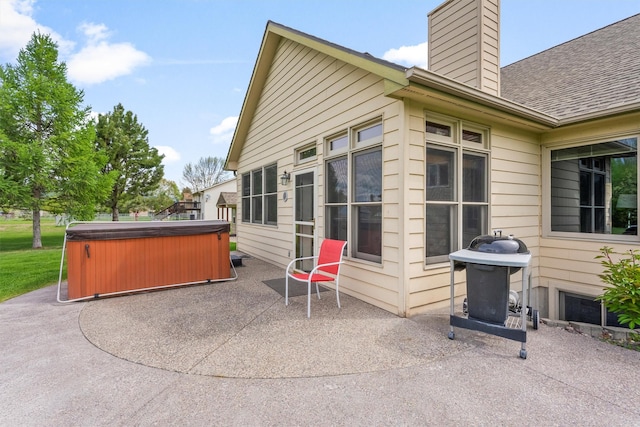1815 Homestead Dr, Missoula, MT 59808 - back of property with a hot tub, a patio, a chimney, and a shingled roof