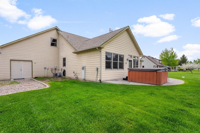 1815 Homestead Dr, Missoula, MT 59808 - rear view of house with a hot tub, a lawn, a patio area, a shingled roof, and central air condition unit