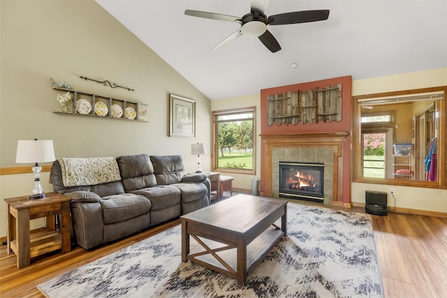 1815 Homestead Dr, Missoula, MT 59808 - living room featuring vaulted ceiling, wood finished floors, ceiling fan, a tiled fireplace, and baseboards
