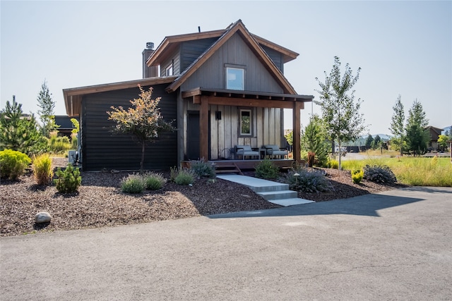 34 Park Cottage Way, Eureka, MT 59917 - view of front of home featuring a porch, a chimney, and board and batten siding