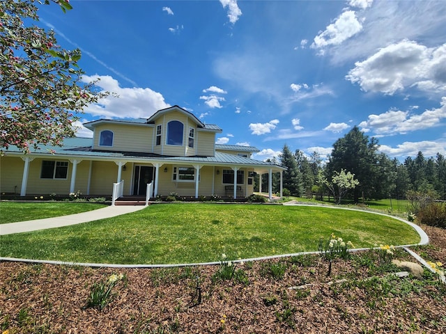 farmhouse inspired home with metal roof, a front lawn, a porch, and a standing seam roof